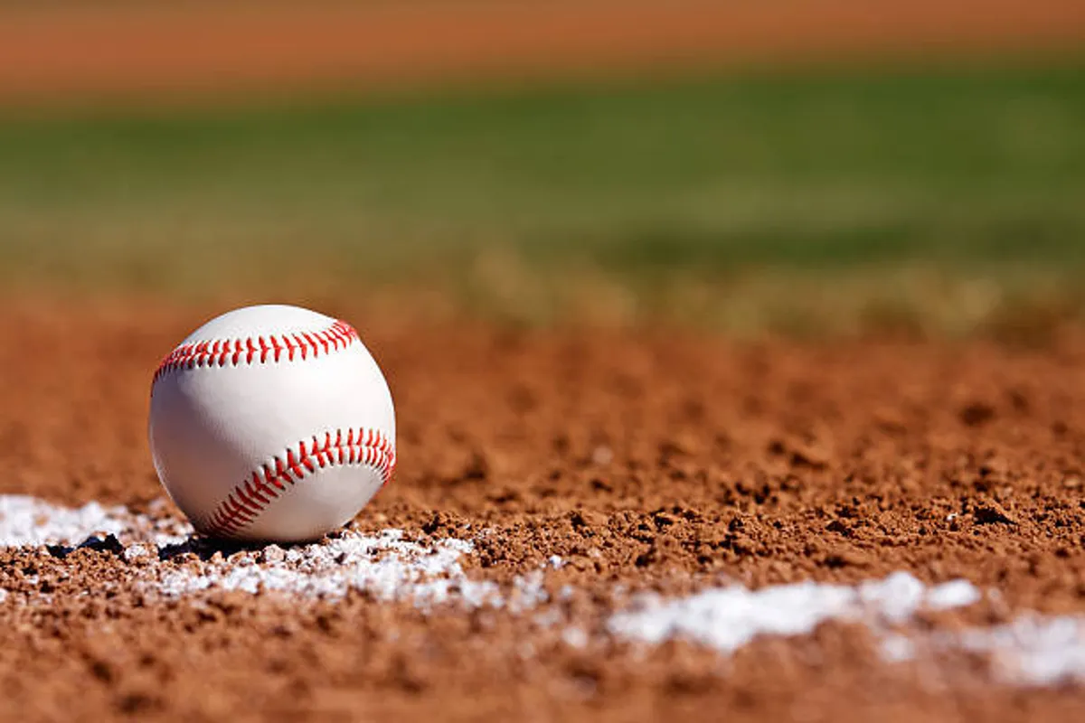 A close-up view of a baseball field's dirt infield and white chalk line, capturing the excitement of playing or watching a game at a local park.